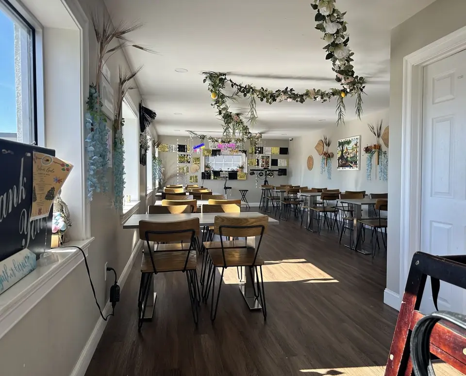 The Philly Pinoy dining room with wooden chairs and flower garlands